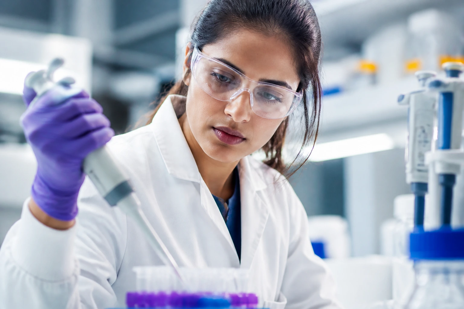 Close-up portrait of a scientist in a bright AstraZeneca laboratory, representing sponsorship