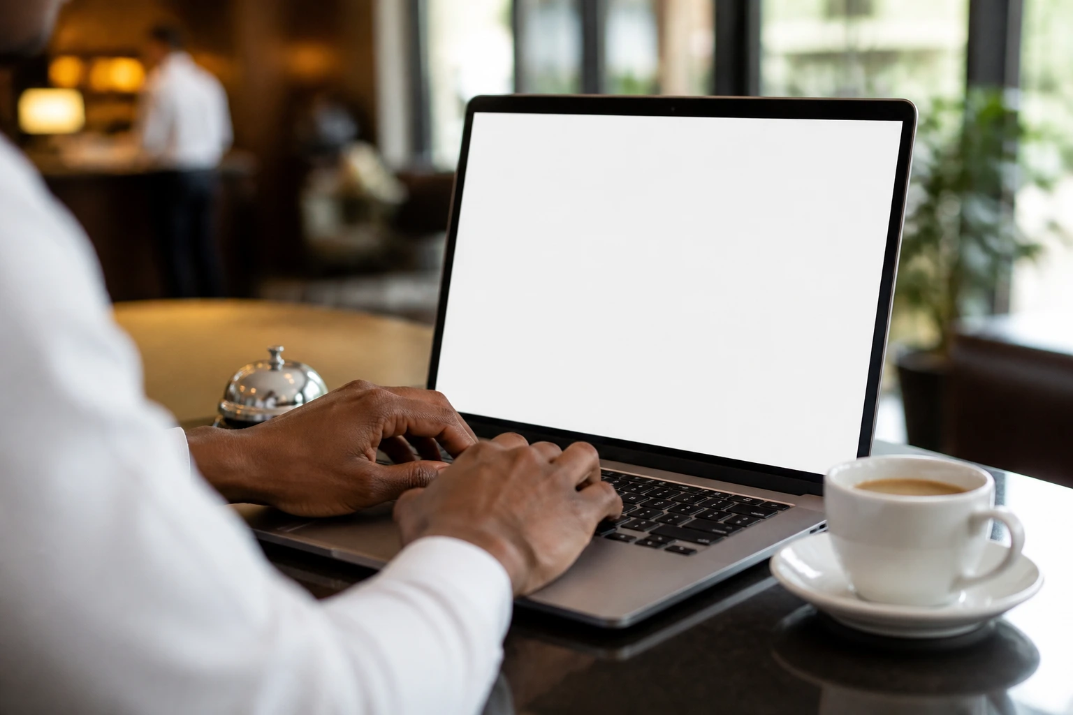 Close-up of hands typing on a laptop with a blank document on screen