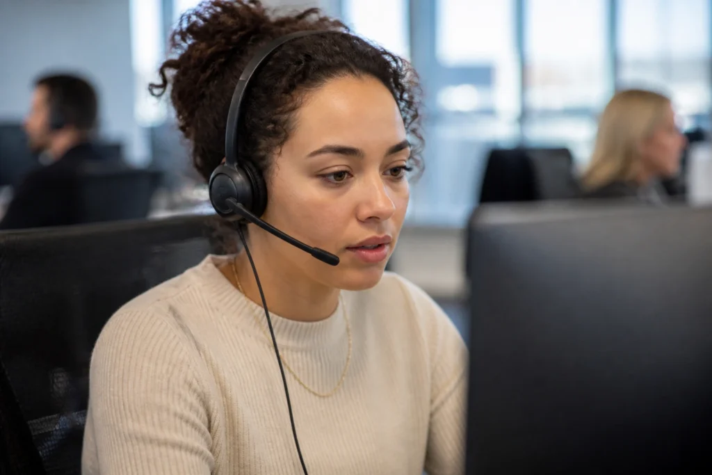 Close-up of a real person wearing a headset in a call center-like environment
