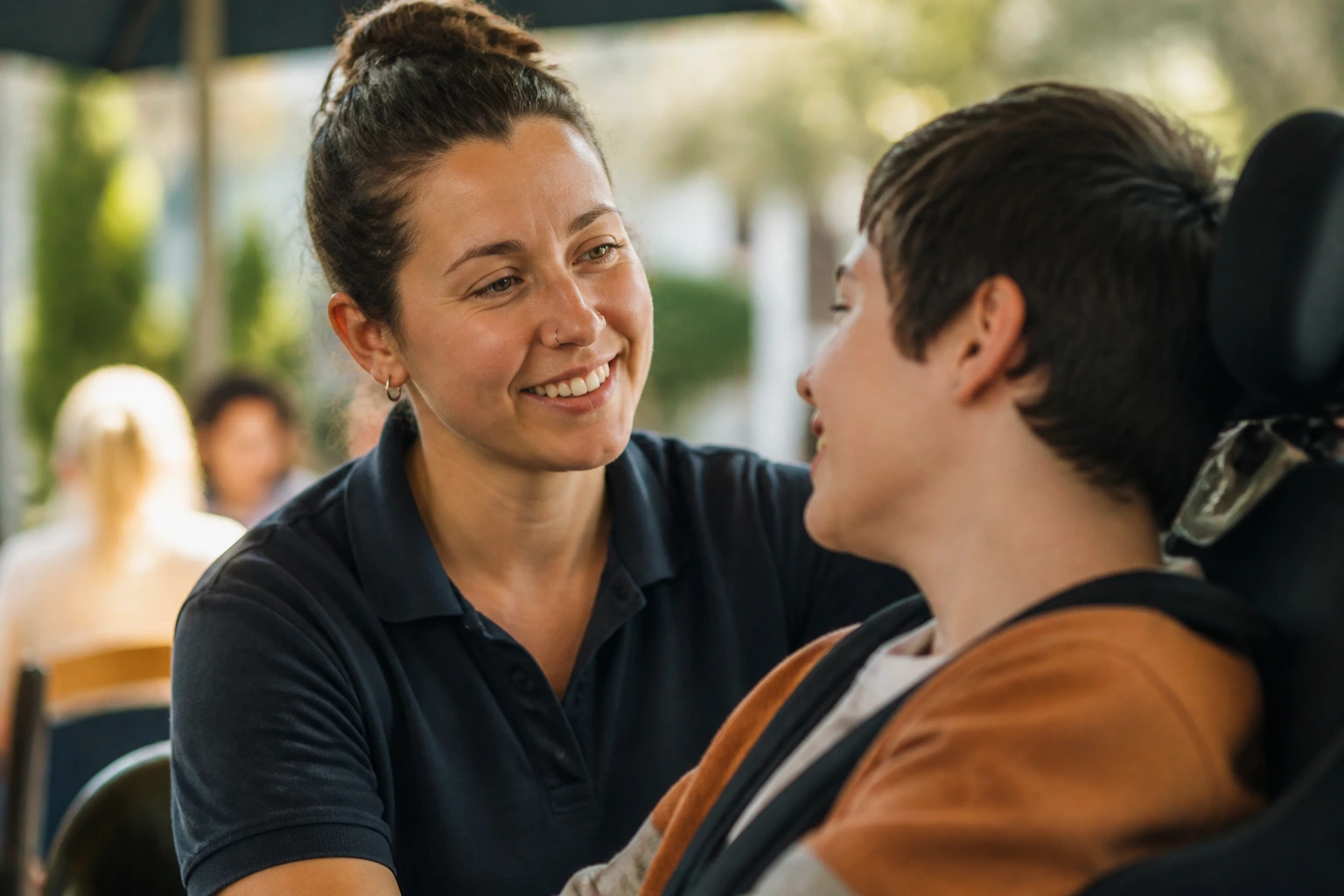 Close-up portrait of a compassionate disability support worker with a blurred community backdrop
