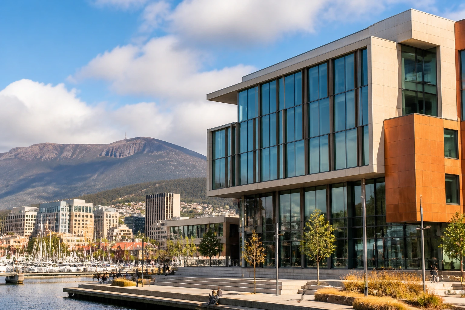 Close-up of Hobart waterfront university building with mountain backdrop, suggesting niche science and tourism