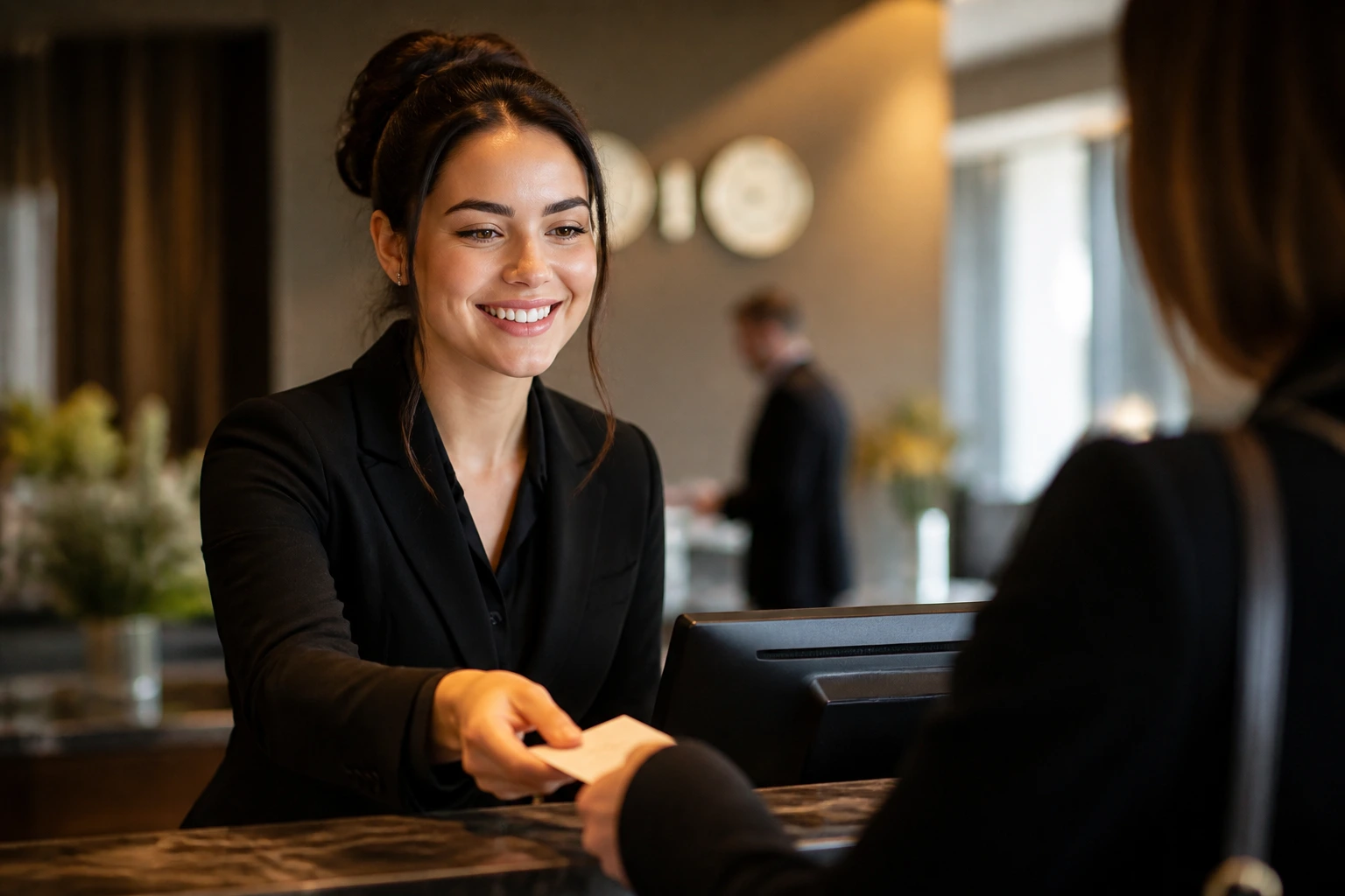Close-up of a hotel front desk agent at a busy lobby counter