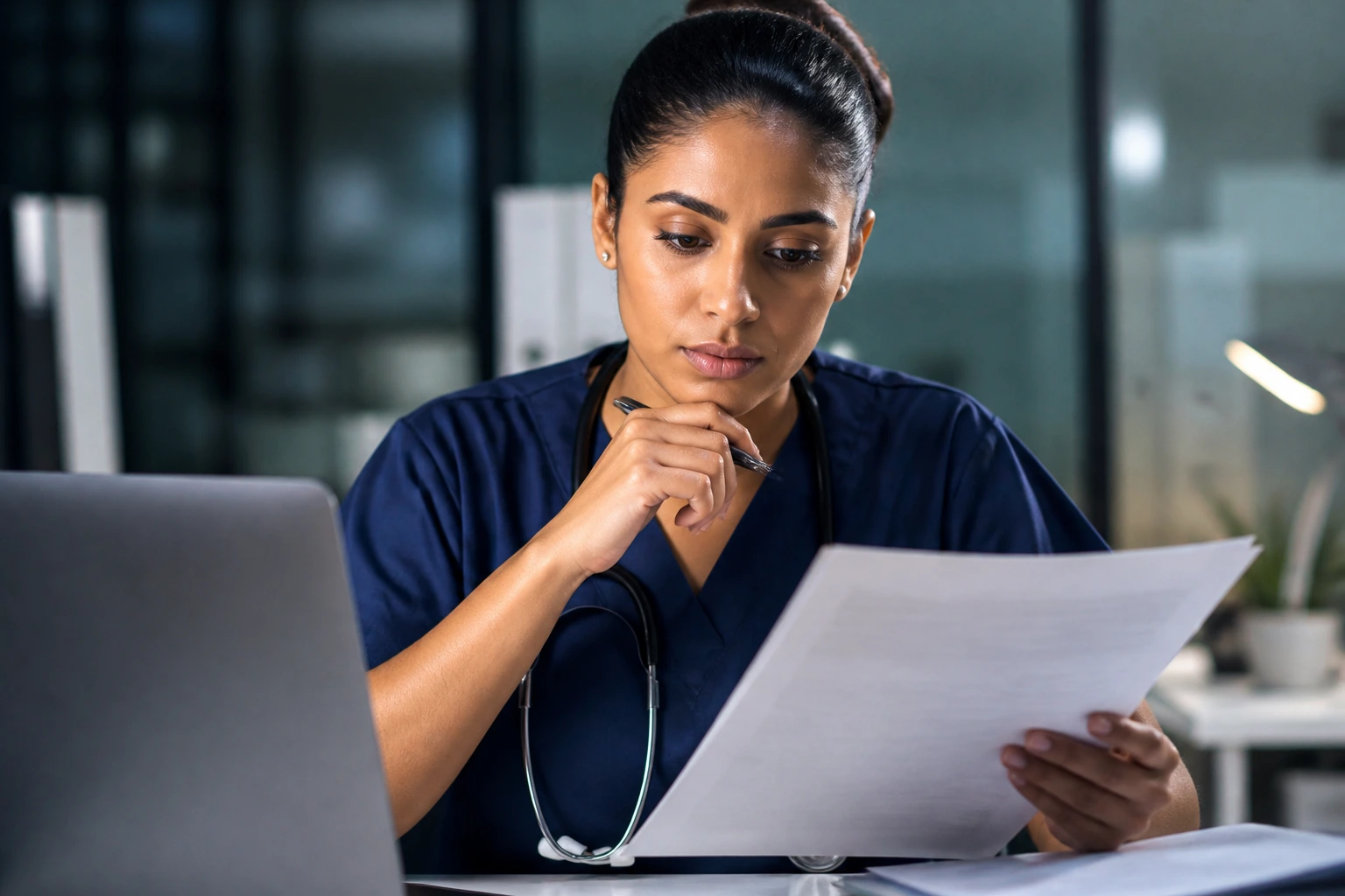 Nurse reviewing provincial regulatory assessment documents in an office.