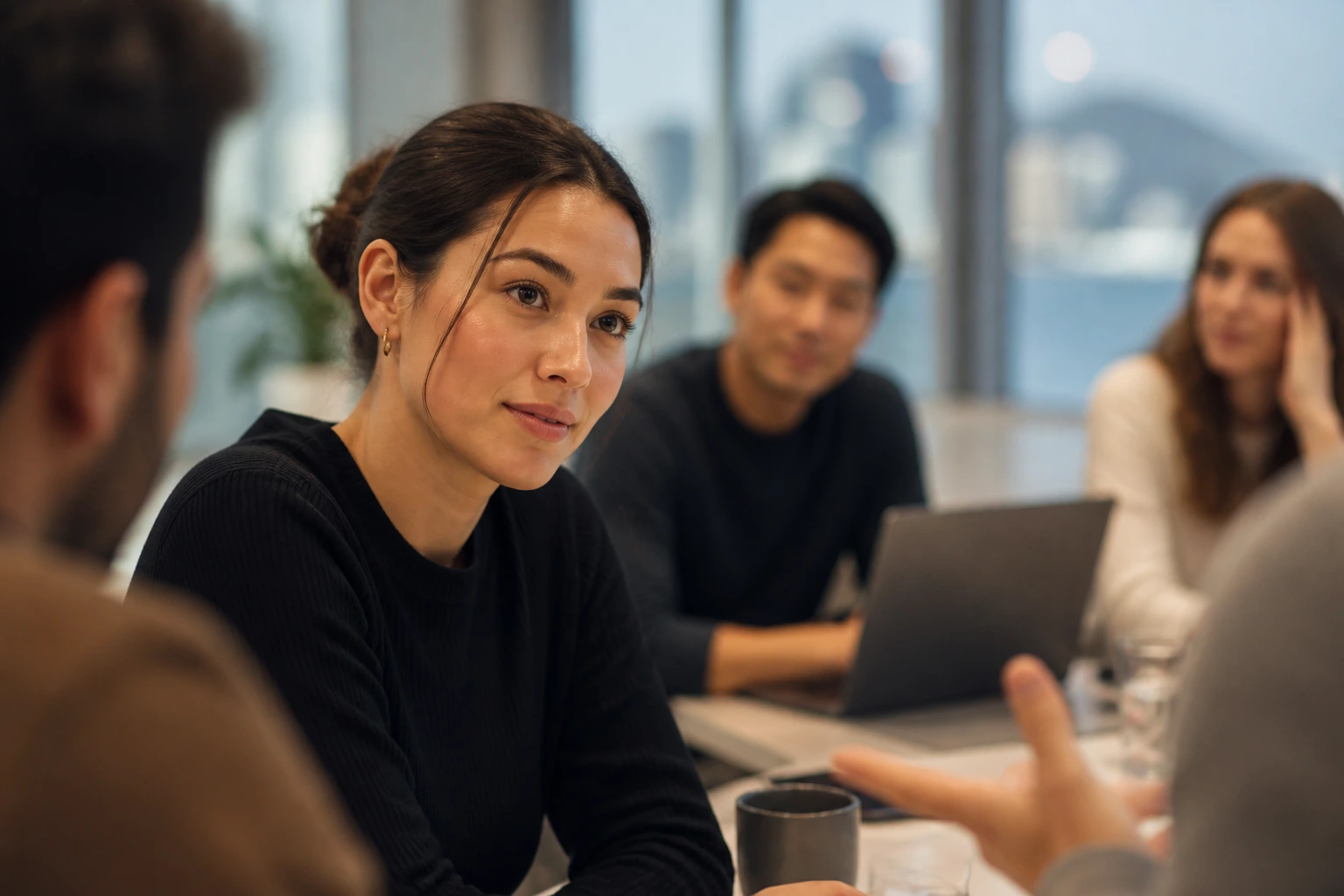 Portrait of a real person in a team meeting demonstrating humility and listening.