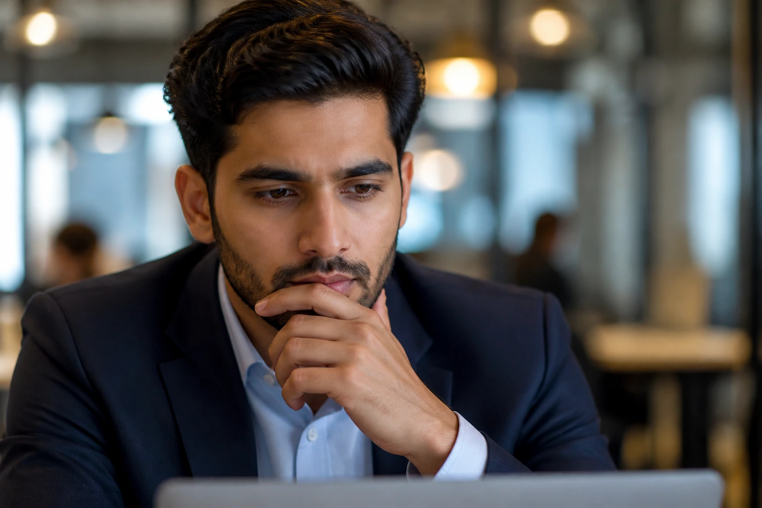 Close-up portrait of a professional at a desk contemplating sponsorship options in a warm office
