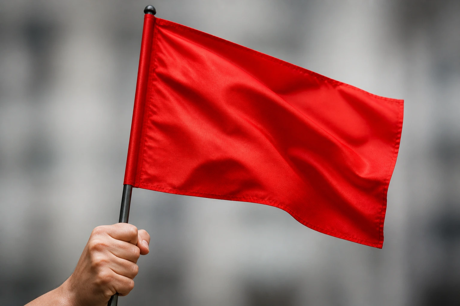 Red flag symbol held in hand indicating warning signs
